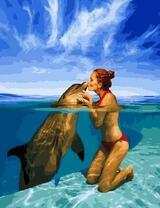 Девушка играет с дельфином