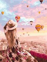 Девушка в шляпе на фоне парада воздушных шаров