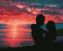 Пара на фоне заходящего в море солнца