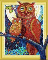 Две совы на дереве на фоне луны