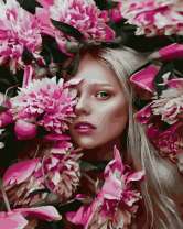 Белокурая девушка в цветущих пионах