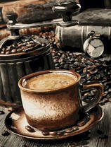 Кофемолка и чашечка крепкого кофе