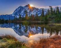 Отражение гор и солнца в водах озера