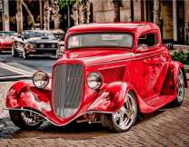 Старинный красный автомобиль в современном городе