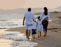 Семья гуляет по берегу моря