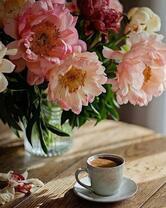 Крепкий кофе на столе с пионами