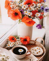 Чашечка крепкого чая и букет ромашек, маков и васильков