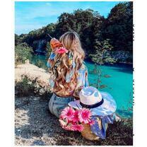 Девушка с букетом гербер у чистого озера