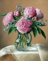 Розовые пионы в стеклянной вазе на столе