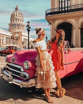 Девушки у старинного автомобиля на солнечной Кубе