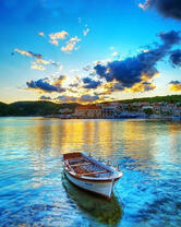 Лодка у причала с видом на небольшой городок