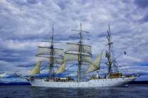 Красивая белая яхта с парусами у города