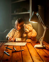 Мальчик рисует с медвежонком