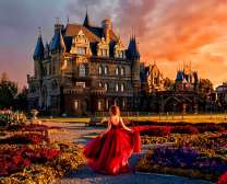 Девушка в красном платье на фоне замка