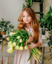 Девочка с охапкой белых тюльпанов