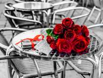 Букет красных роз на столике уличного кафе