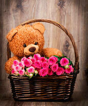 Плюшевый мишка в корзинке с розами