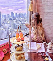 Девушка смотрит на город за завтраком