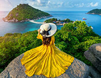 Девушка на горе в желтом платье со шляпкой