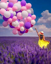 Девушка с воздушными шарами гуляет по лавандовому полю