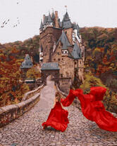 Девушка в красном платье на фоне старого замка