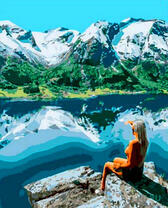 Девушка смотрит на горное озеро с высоты