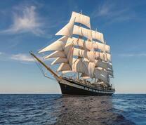 Черный корабль с белыми парусами на морской глади