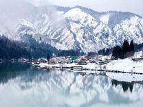 Отражение гор и городка в водах озера