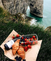 Вино с ягодами и круассанами на скале над морем
