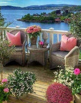 Беседка с плетённой мебелью в цветах над морем