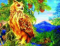 Большой филин под еловой веткой