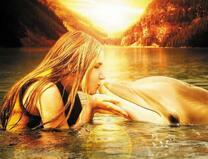 Девушка в море целует дельфина