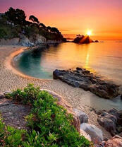 Лучи восходящего солнца в морской бухте