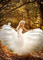 Девушка в белом воздушном платье под осенними деревьями