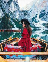 Девушка в лодке на озере в горах