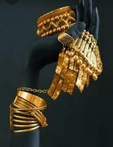 Золотые украшения на черной руке