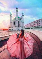 Девушка в розовом платье на фоне храма