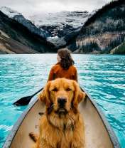 Девушка и пёс в лодке на озере