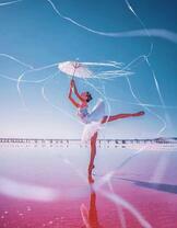 Балерина на розовом озере под зонтиком