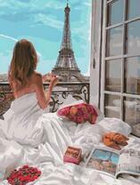 Девушка в постели на балконе Парижа