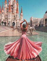 Девушка в легком платье на фоне сказочного замка