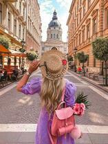 Счастливая девушка на фоне собора в городе