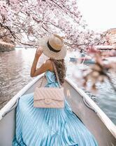 Нежная девушка в лодке под цветущим деревом