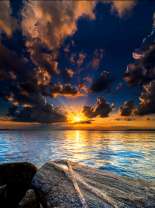 Вид на восходящее солнце с берега