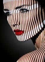 Девушка в полосках тени и лучах солнца