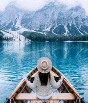 Девушка в лодке возле гор