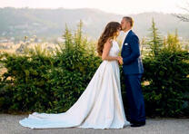 Жених и невеста в белом платье целуются