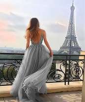 Красивая девушка в сером платье на фоне Эйфелевой башни