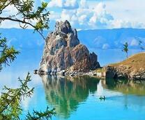 Отражение одинокой скалы в водах озера