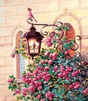 Розовая птичка на фонаре над кустом роз